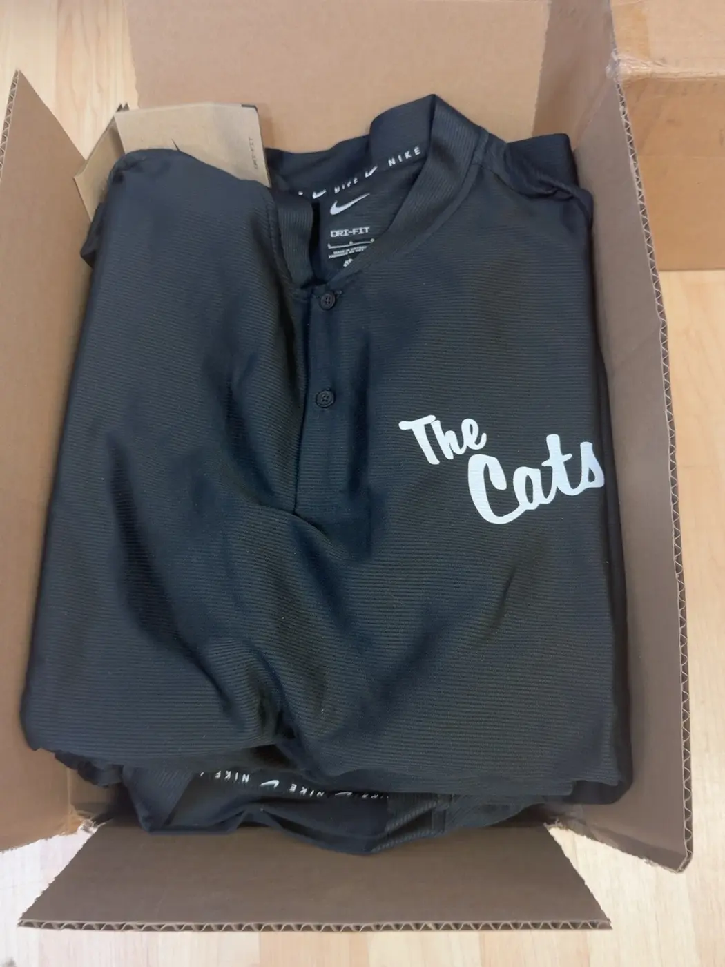 Black team jersey with The Cats lettering