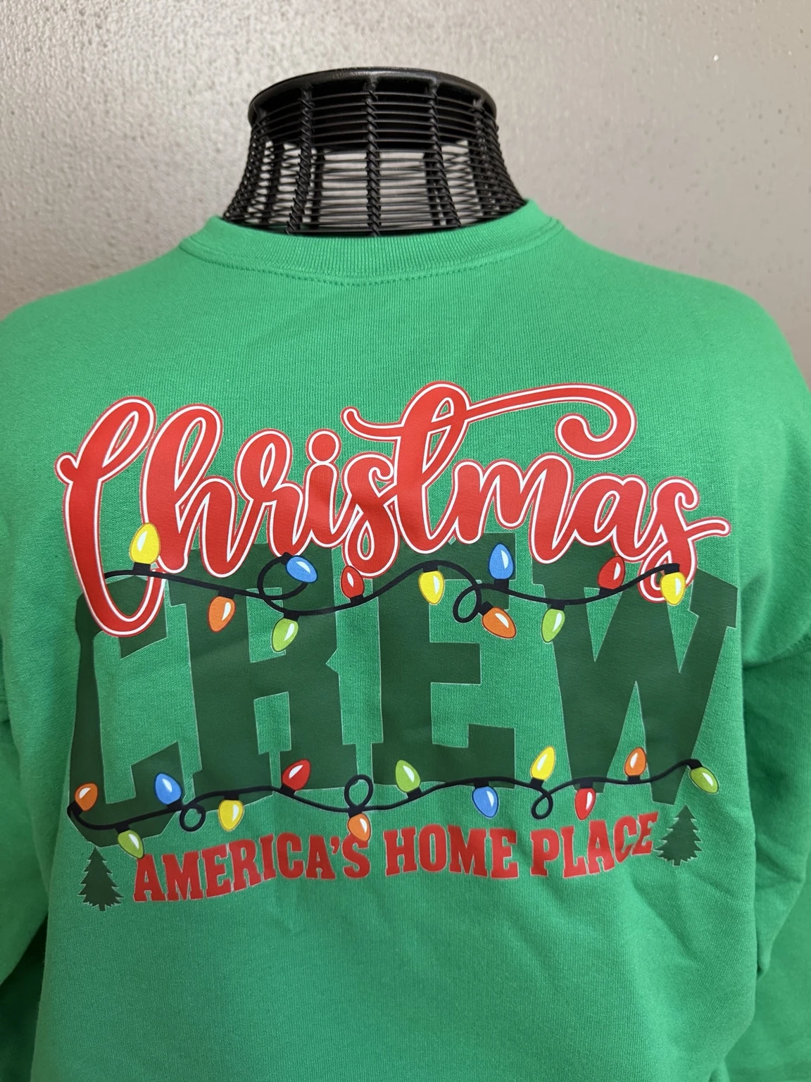 Green Christmas Crew shirt with colorful holiday lights and Americas Home Place lettering