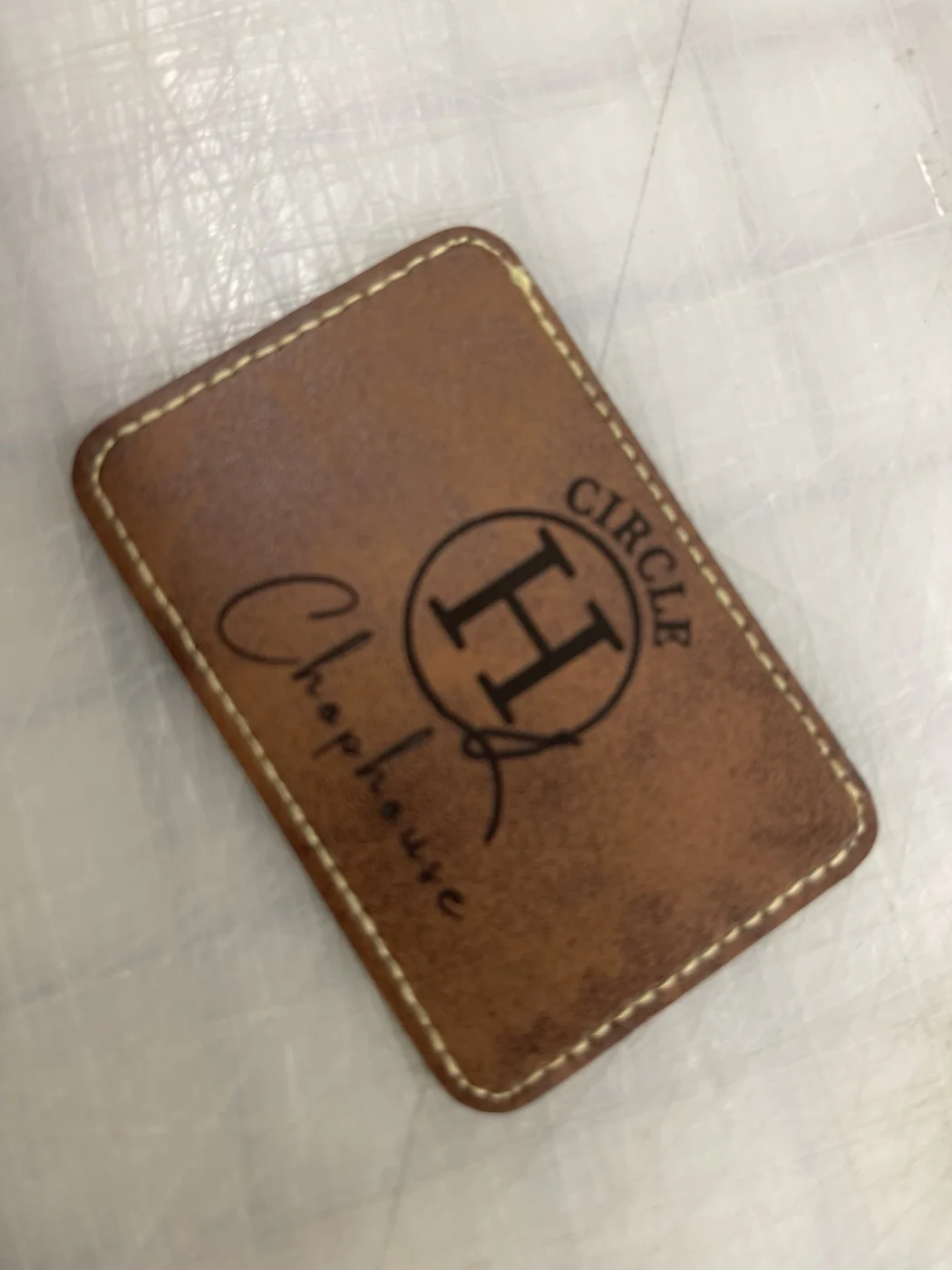 Brown leather patch with Circle H Chophouse logo and stitched border