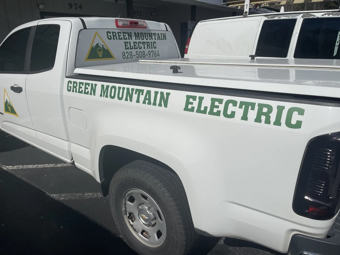 Green Mountain Electric lettering and logo on a white pickup truck