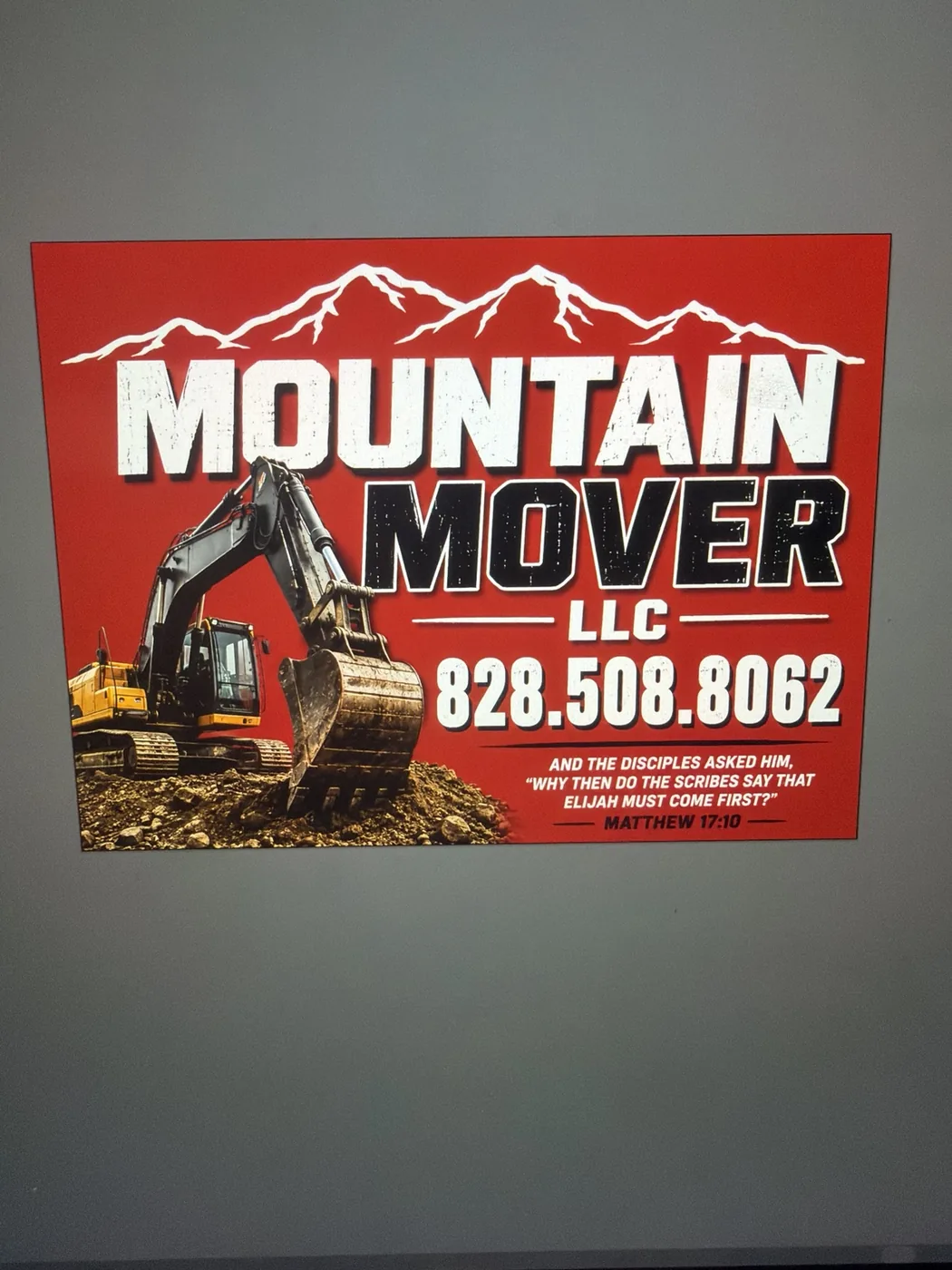 Red Mountain Mover LLC business sign with excavator artwork