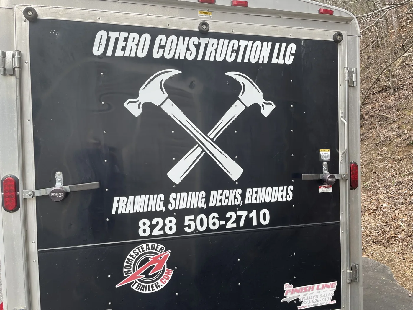 Otero Construction logo and services on a black enclosed trailer