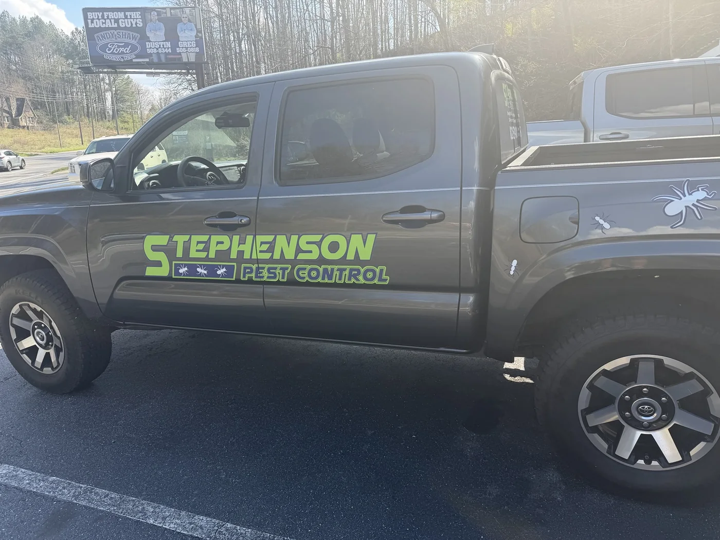 Stephenson Pest Control logo and lettering across a pickup truck's doors and bedside