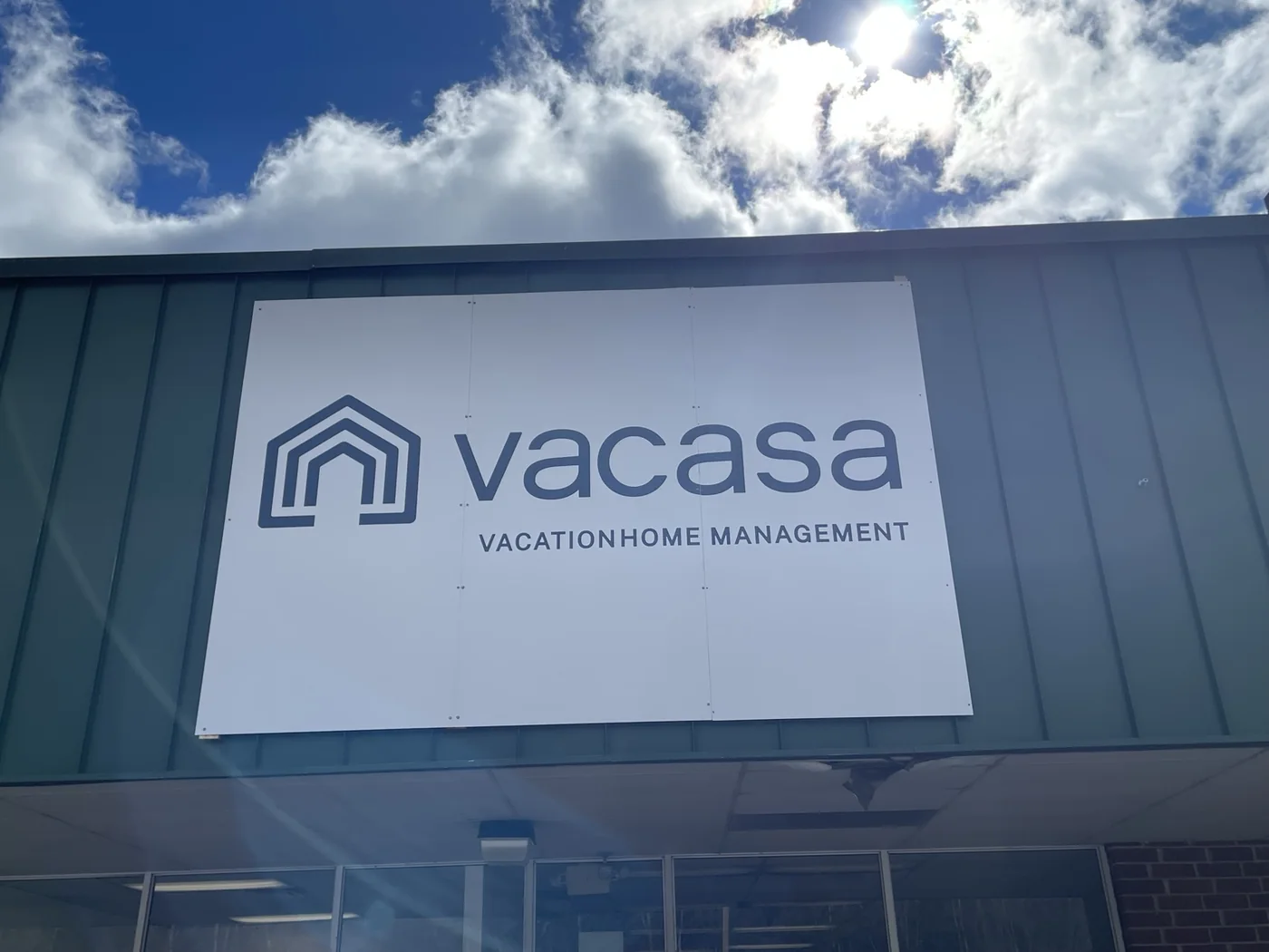 Vacasa vacation home management sign mounted on a storefront