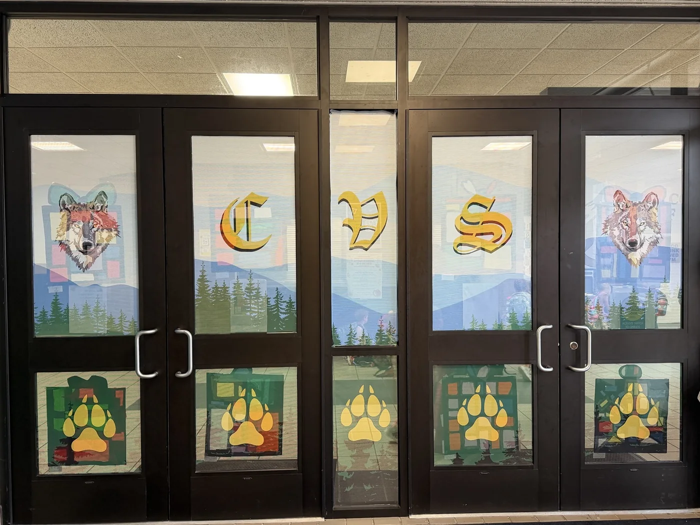Wolf Valley school entrance doors with wolf, lettering and paw graphics